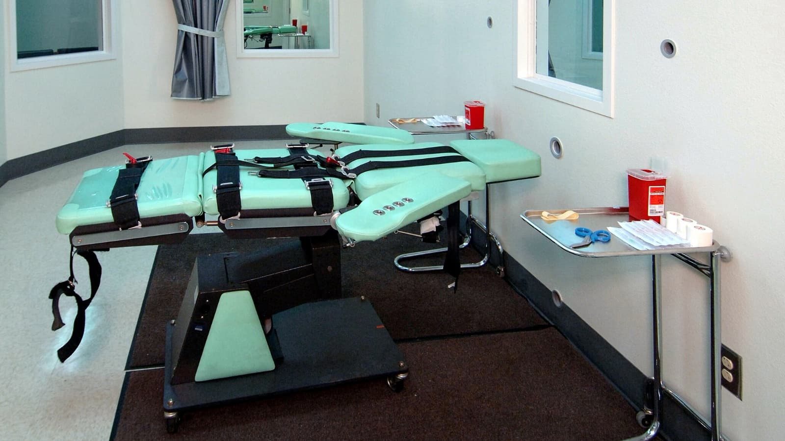 A room with a medical table that has restraining straps